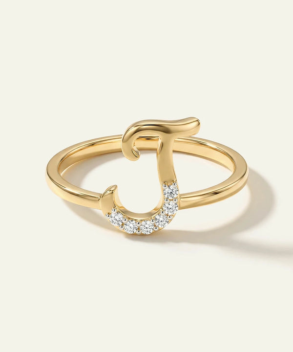 Gold ring with a horseshoe design on a light beige background