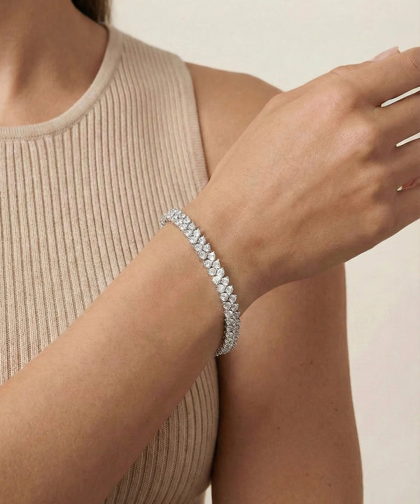 Silver bracelet on a person's wrist with a neutral background