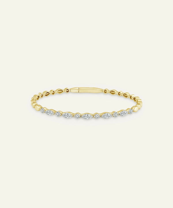 Gold bracelet with diamonds on a light beige background