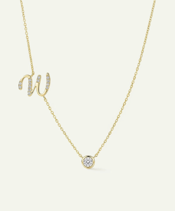 Gold necklace with a diamond pendant on a light beige background