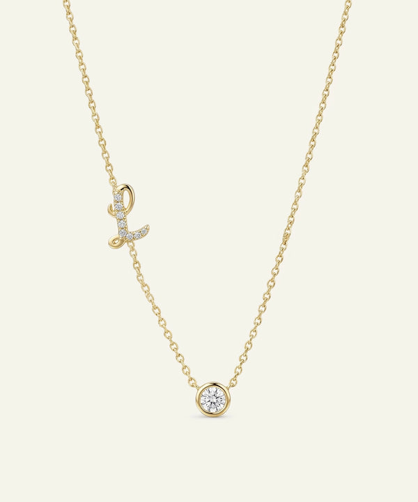 Gold necklace with diamond pendants on a light beige background