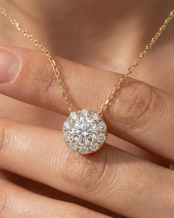 Diamond necklace held between fingers against a blurred background