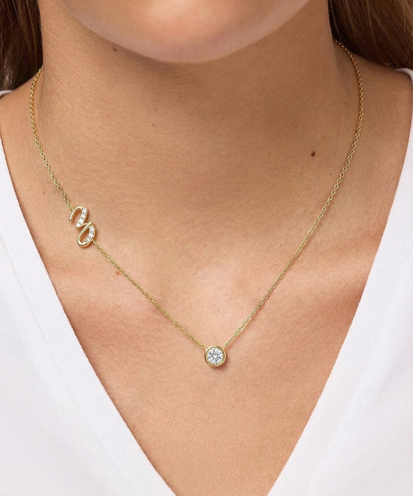 Gold necklace with a pendant on a person wearing a white top