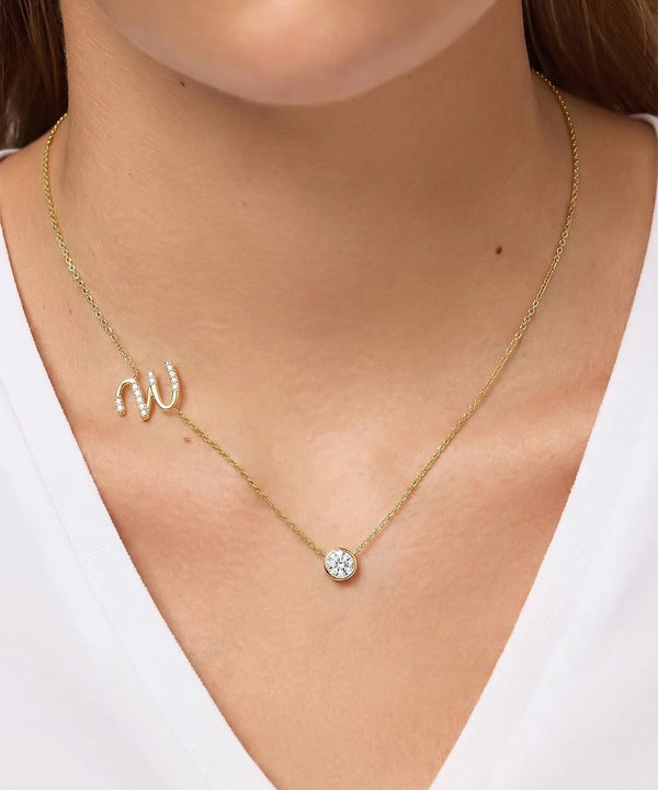 Gold necklace with a small pendant on a person wearing a white top