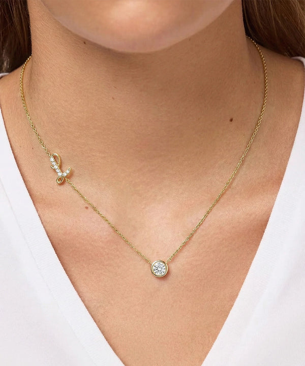 Gold necklace with a round pendant worn by a person against a white background