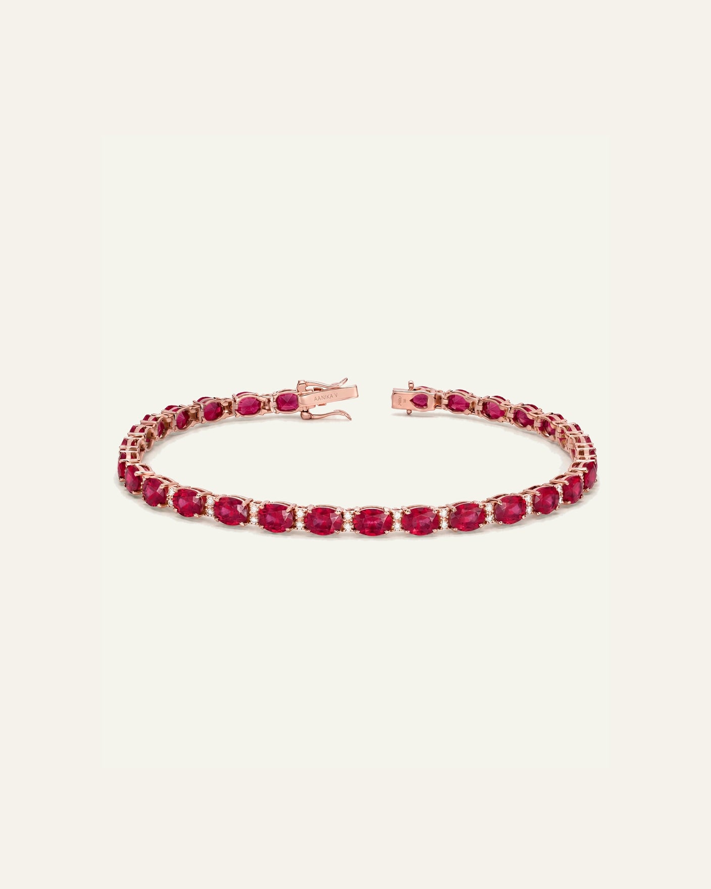 A rose gold tennis bracelet featuring a continuous line of oval-cut deep pinkish-red gemstones, displayed on a clean, solid off-white background.