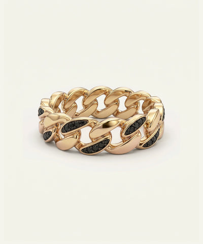 Gold chain-style ring with black stones on a beige background