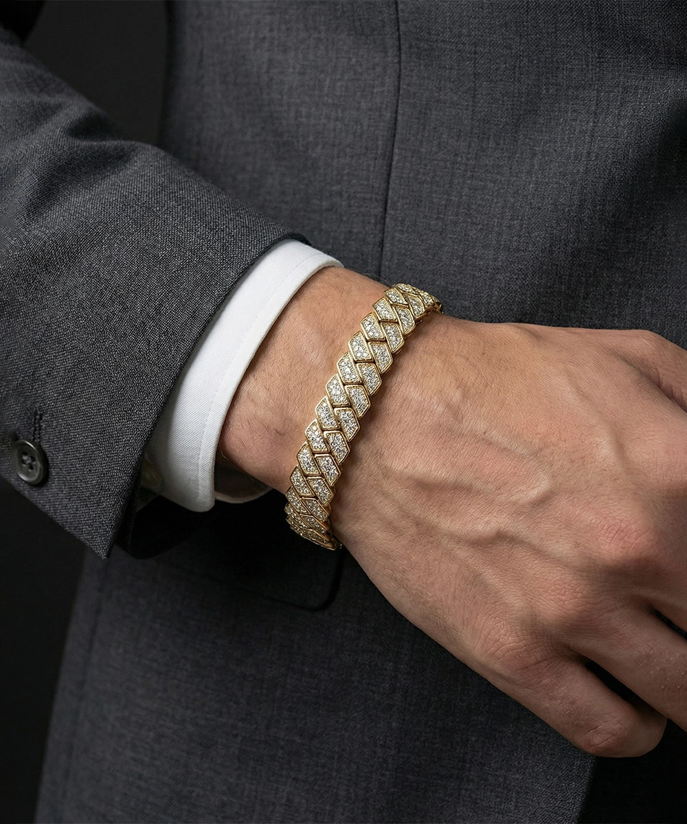 Gold bracelet on a person wearing a gray suit and white shirt.