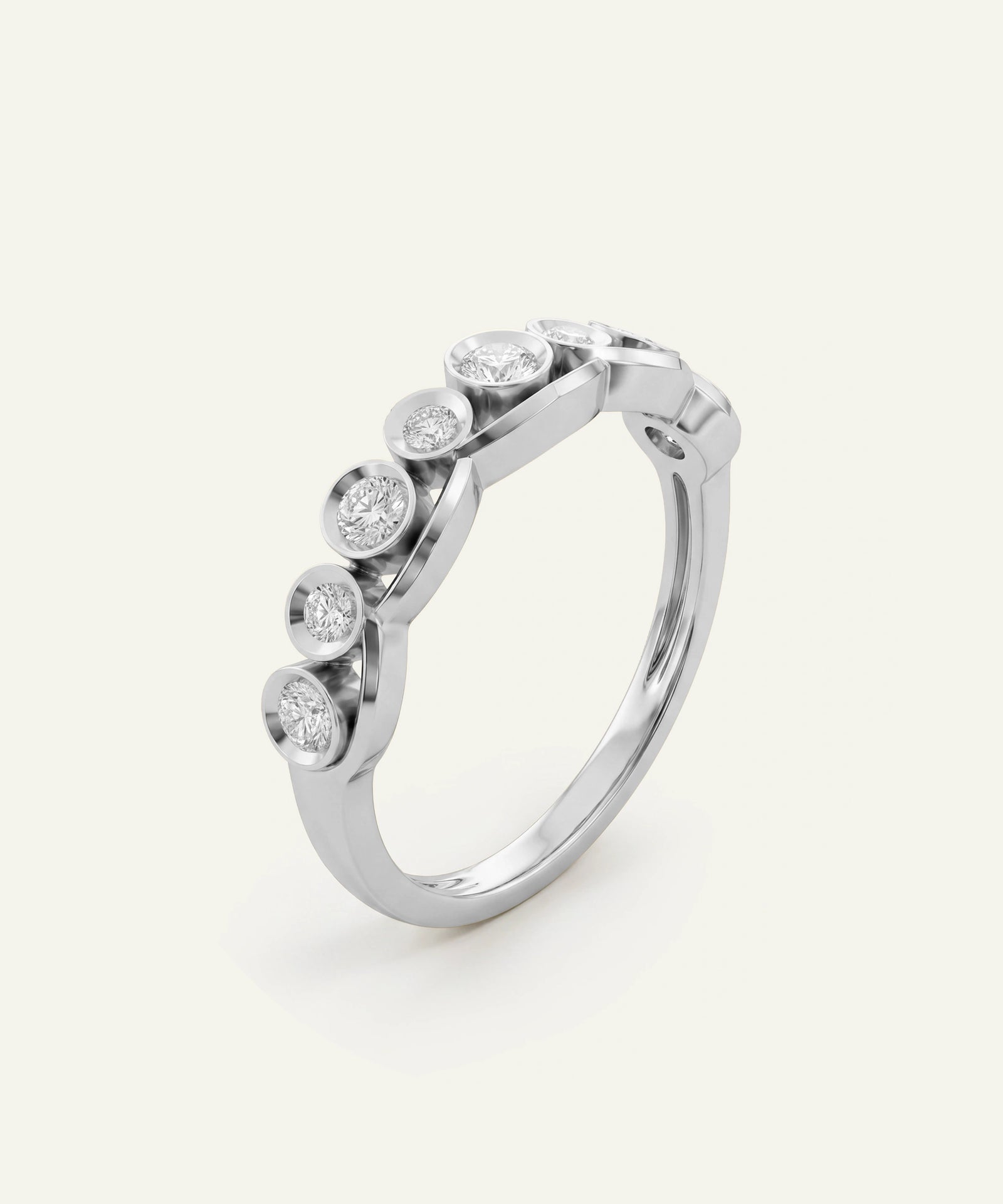 A silver-toned diamond ring featuring a curved band with five bezel-set round diamonds, photographed on a clean, light cream background.
