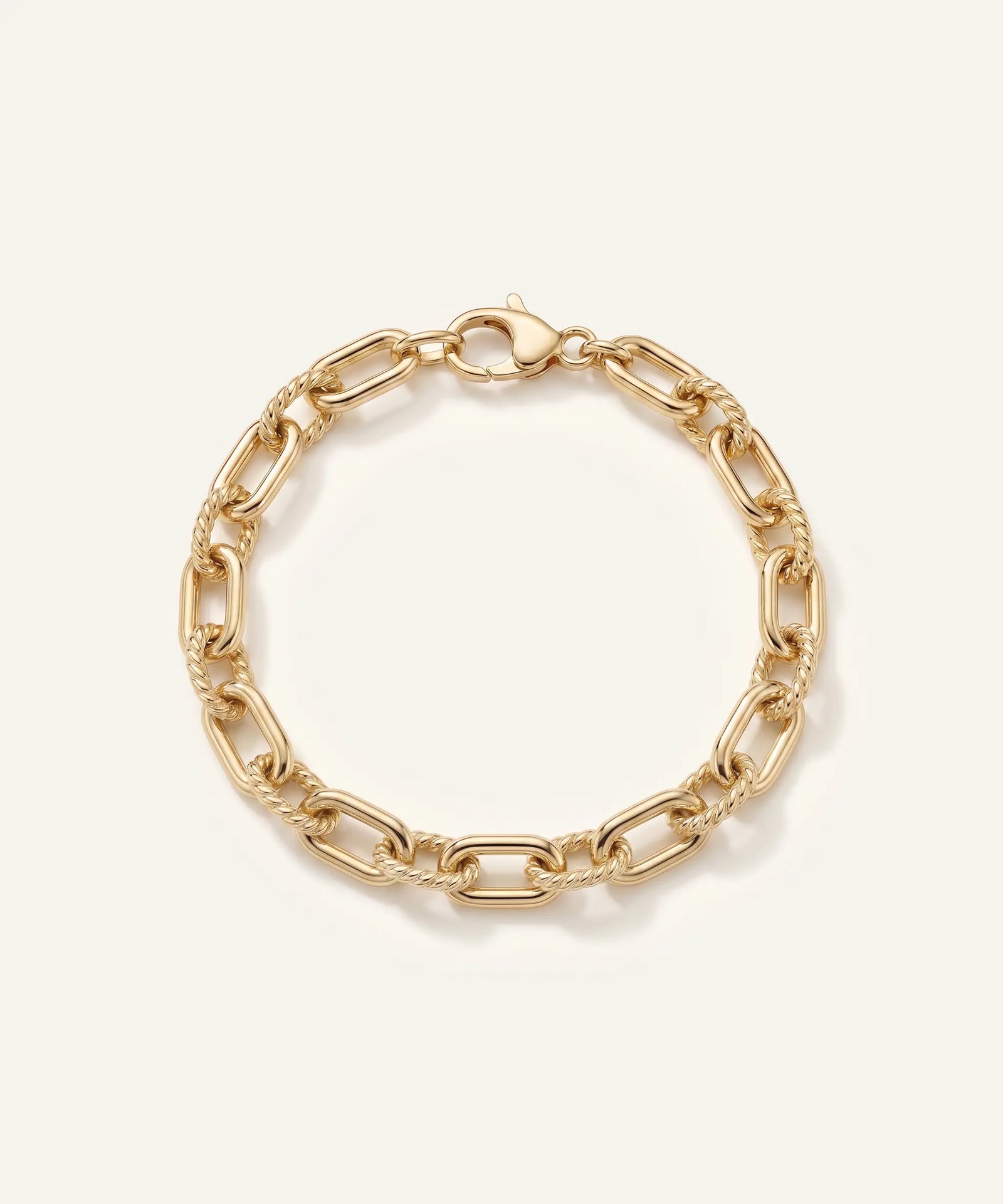 Gold chain bracelet on a light beige background