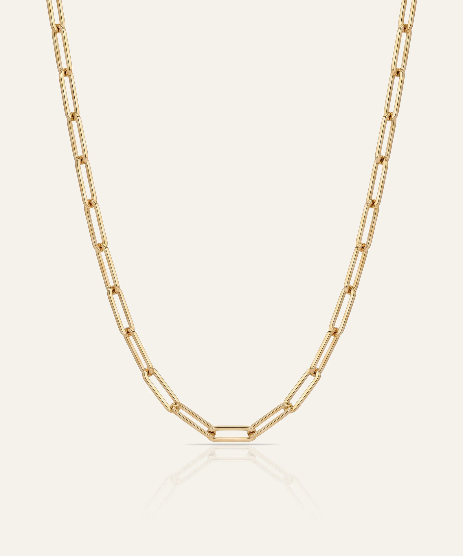 Gold chain necklace on a light beige background