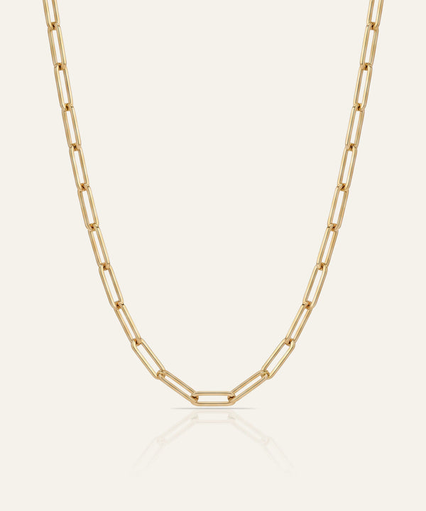 Gold chain necklace on a light beige background