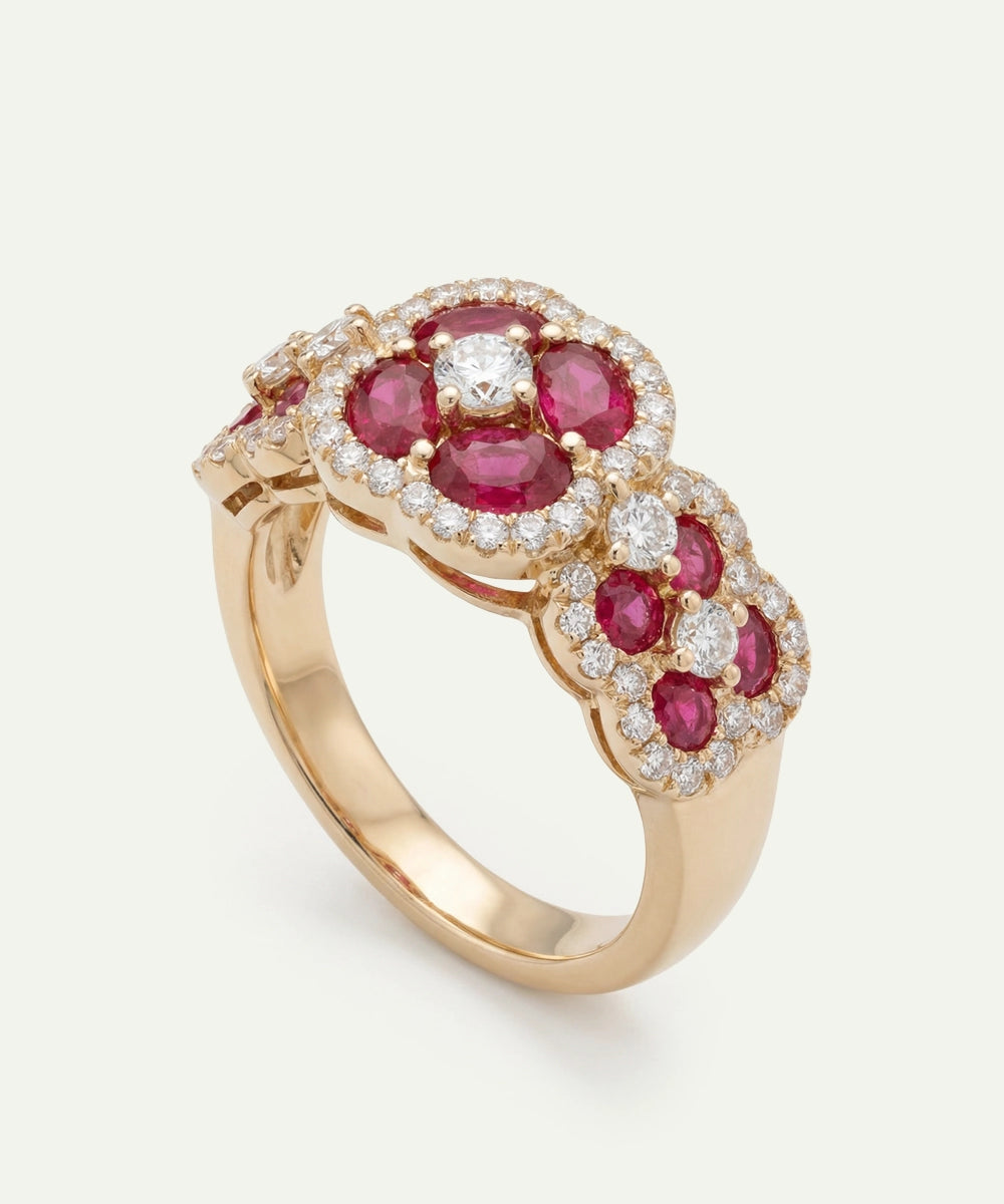 Gold ring with red gemstones and diamonds on a white background
