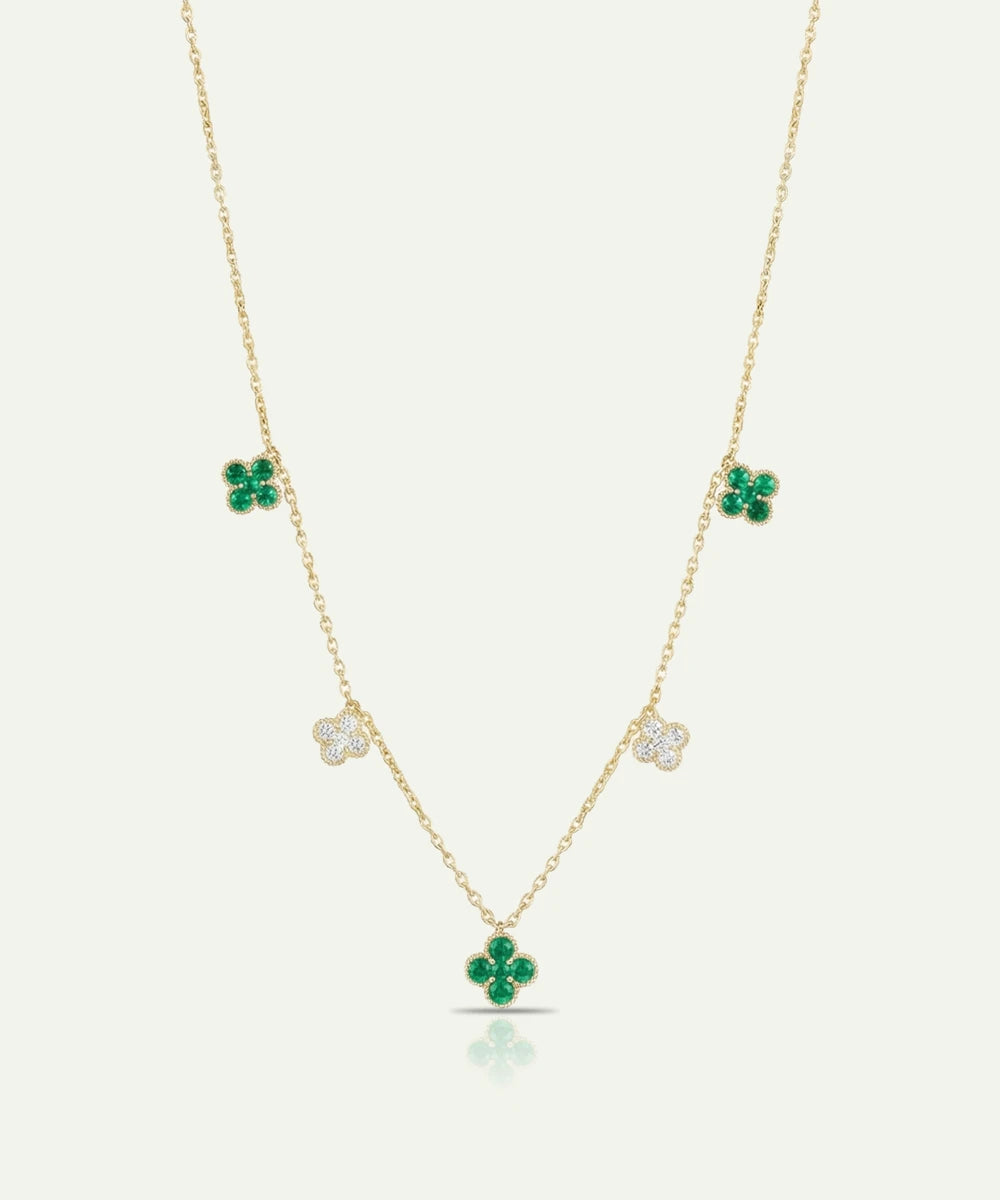 Gold necklace with green clover pendants on a white background