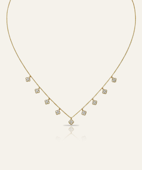 Gold necklace with small diamonds on a light beige background