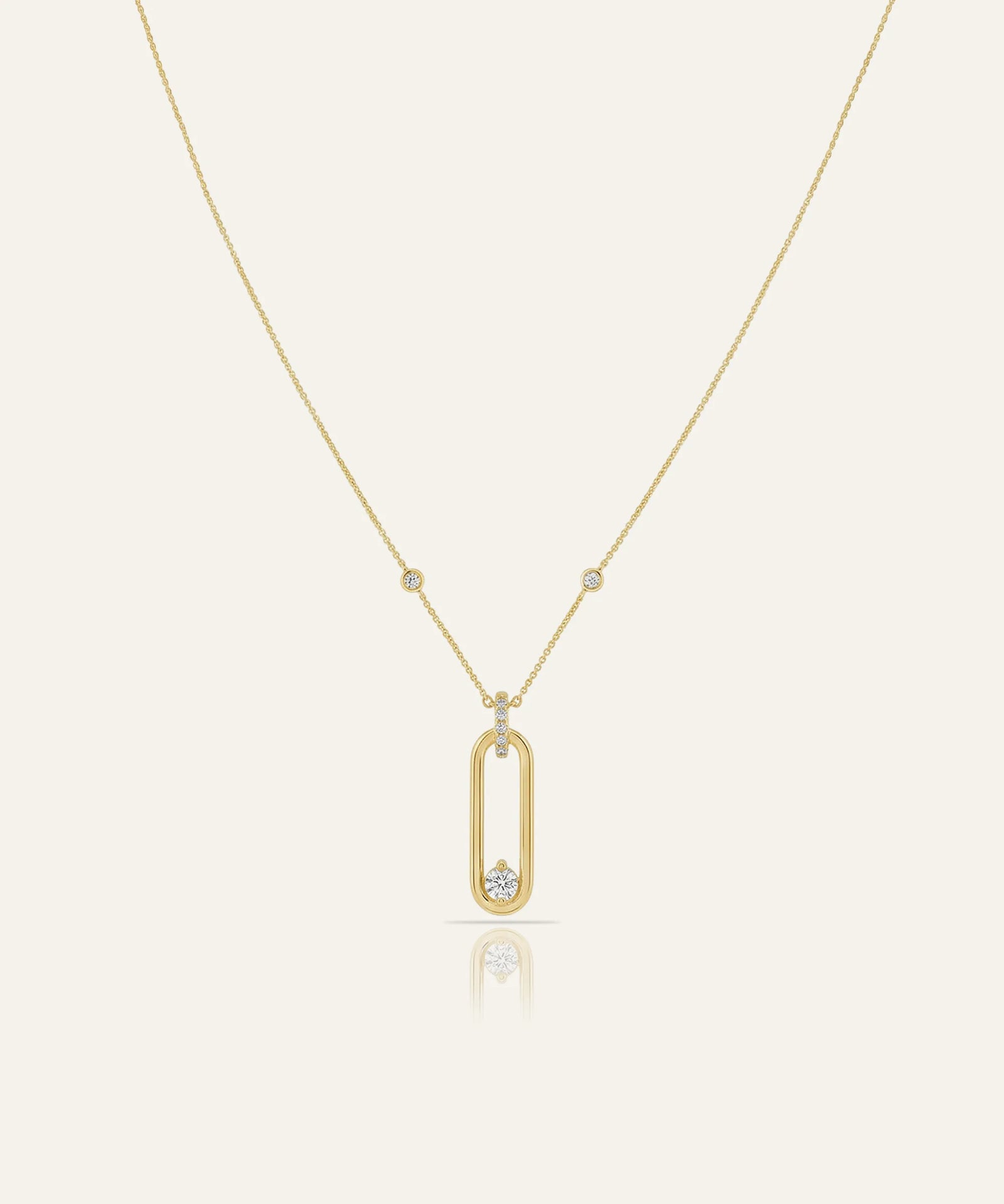 Gold necklace with a unique pendant on a light beige background