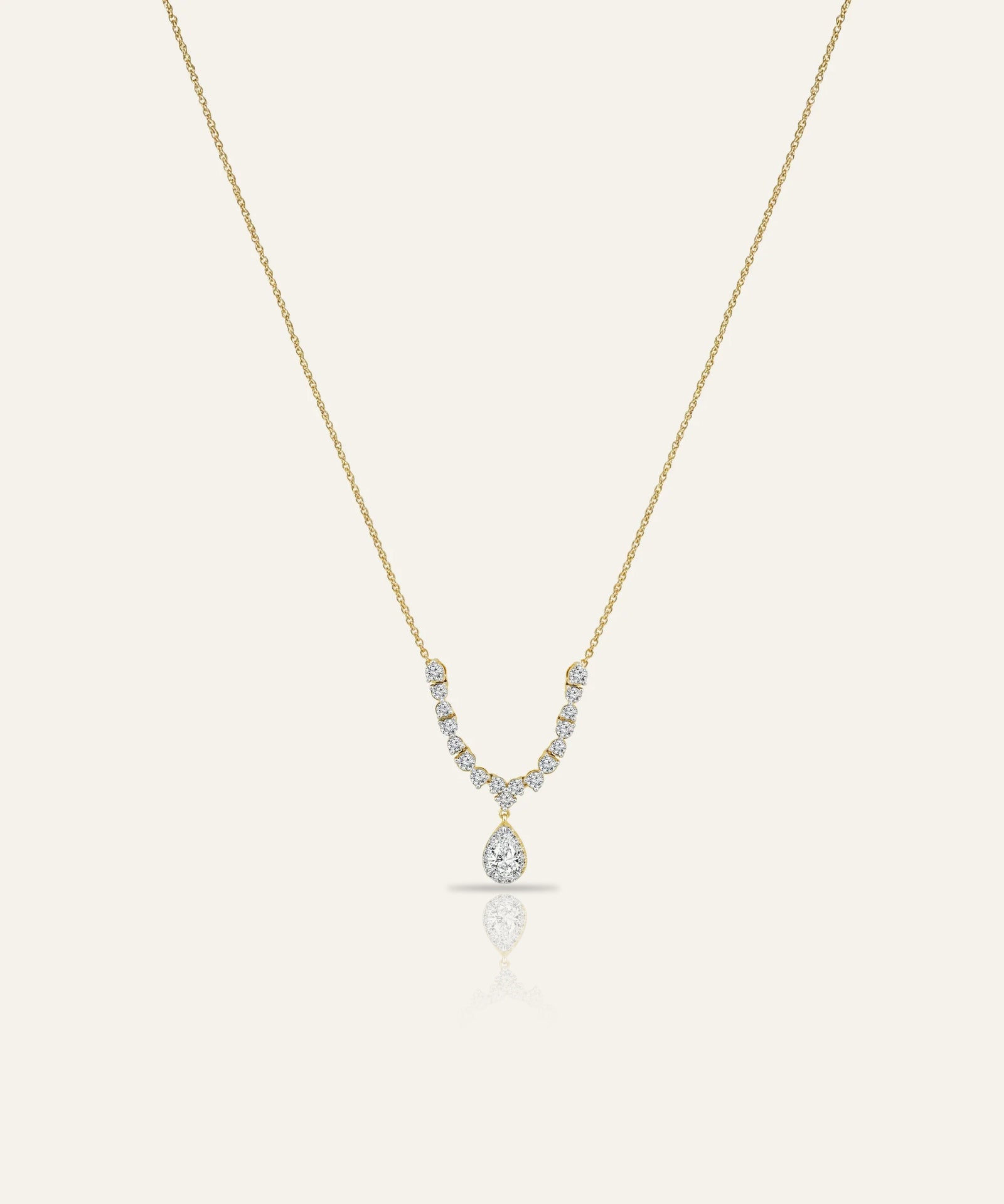 Gold necklace with a diamond pendant on a white background