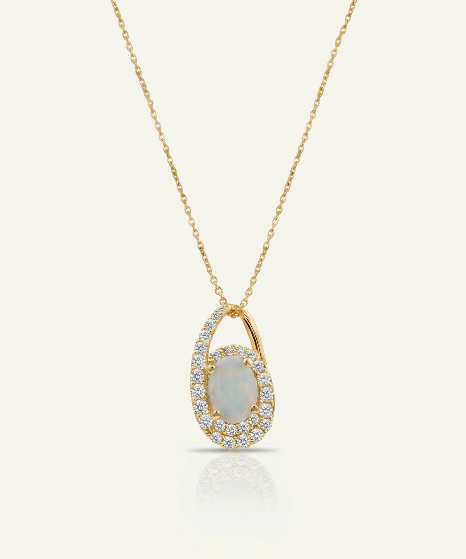 Gold necklace with a pendant featuring an opal stone on a light gray background