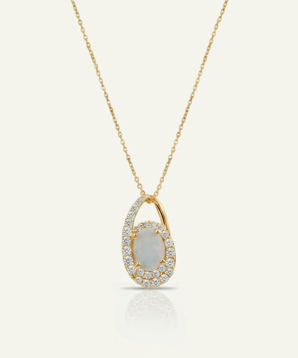 Gold necklace with a pendant featuring an opal stone on a light gray background