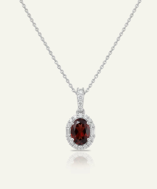 Silver necklace with a red gemstone pendant on a white background