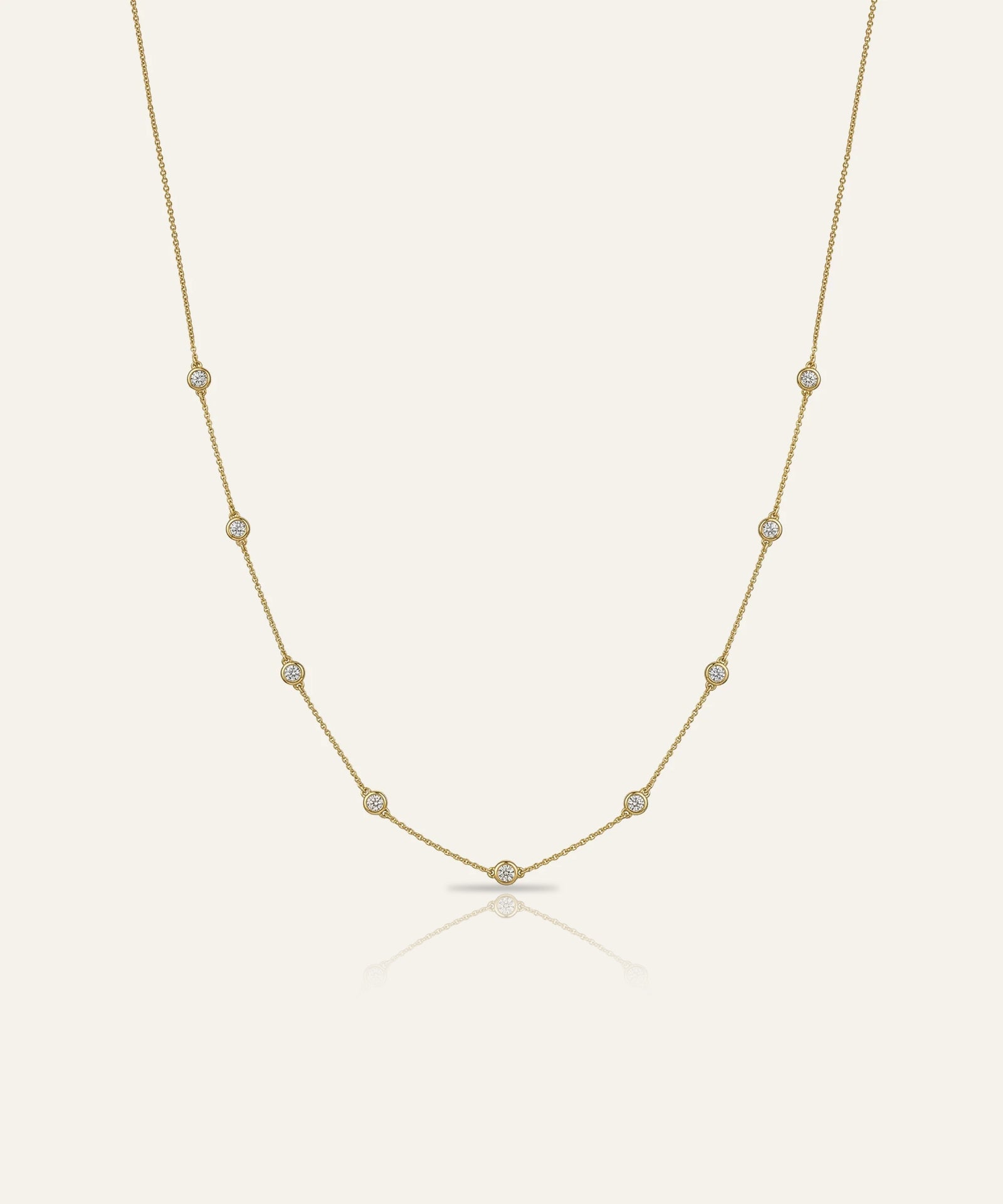 Gold necklace with small pearls on a light beige background