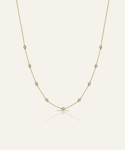 Gold necklace with small pearls on a light beige background
