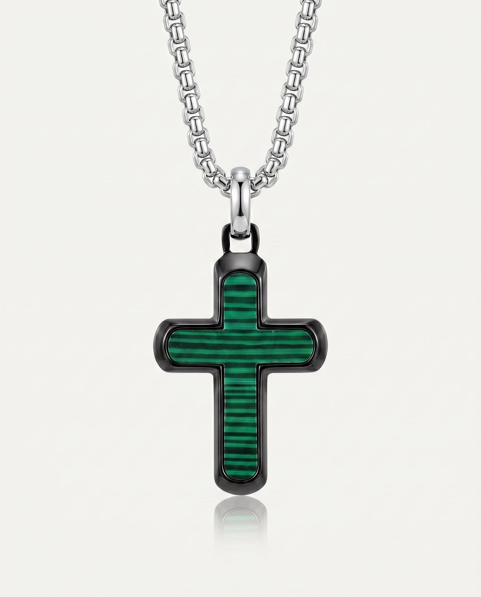 A silver cross pendant necklace with a green striped inlay, suspended from a silver link chain against a light gray background.