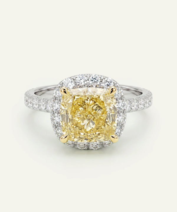 Diamond ring with a yellow center stone on a white background