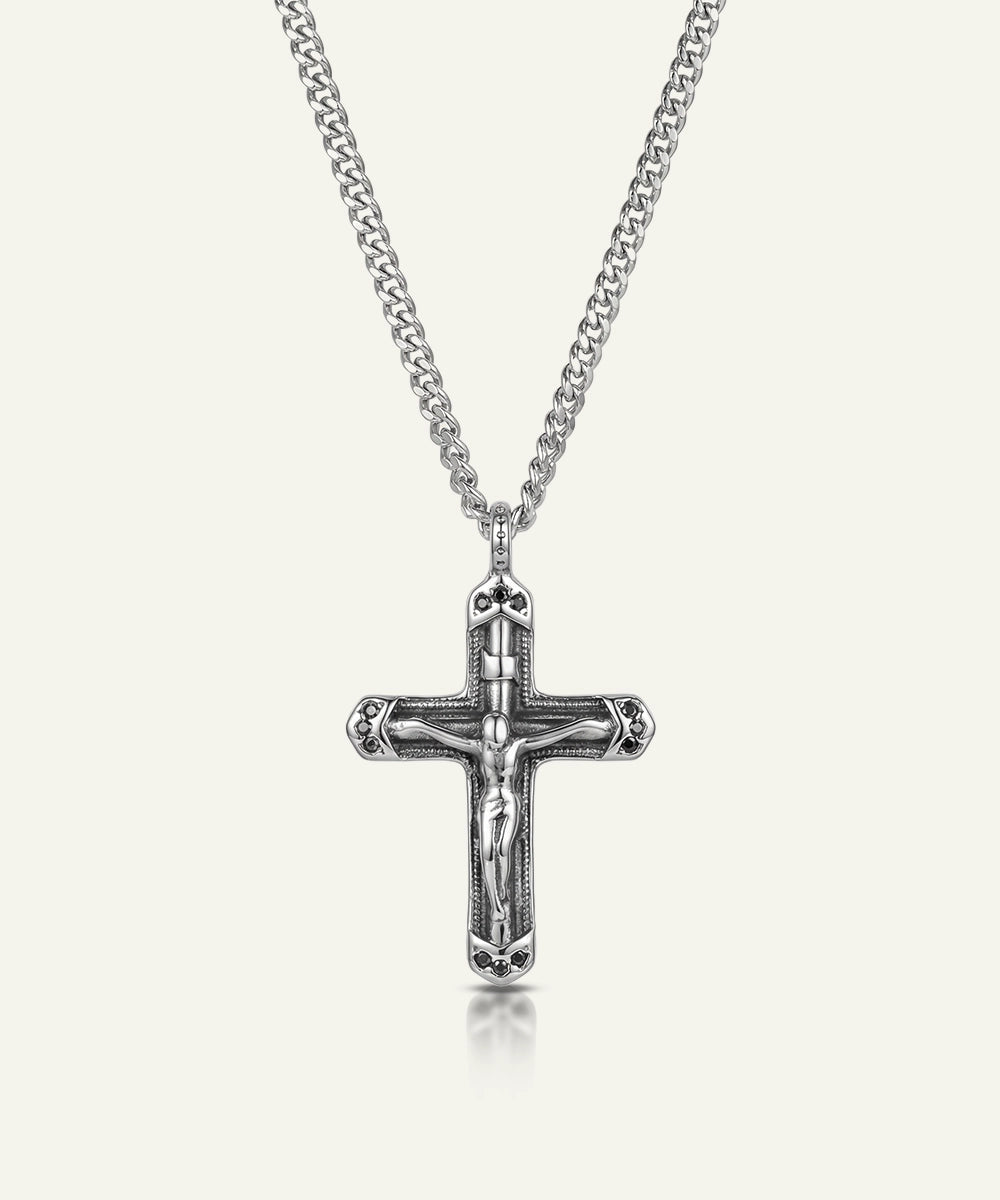 Silver crucifix pendant on a chain against a white background
