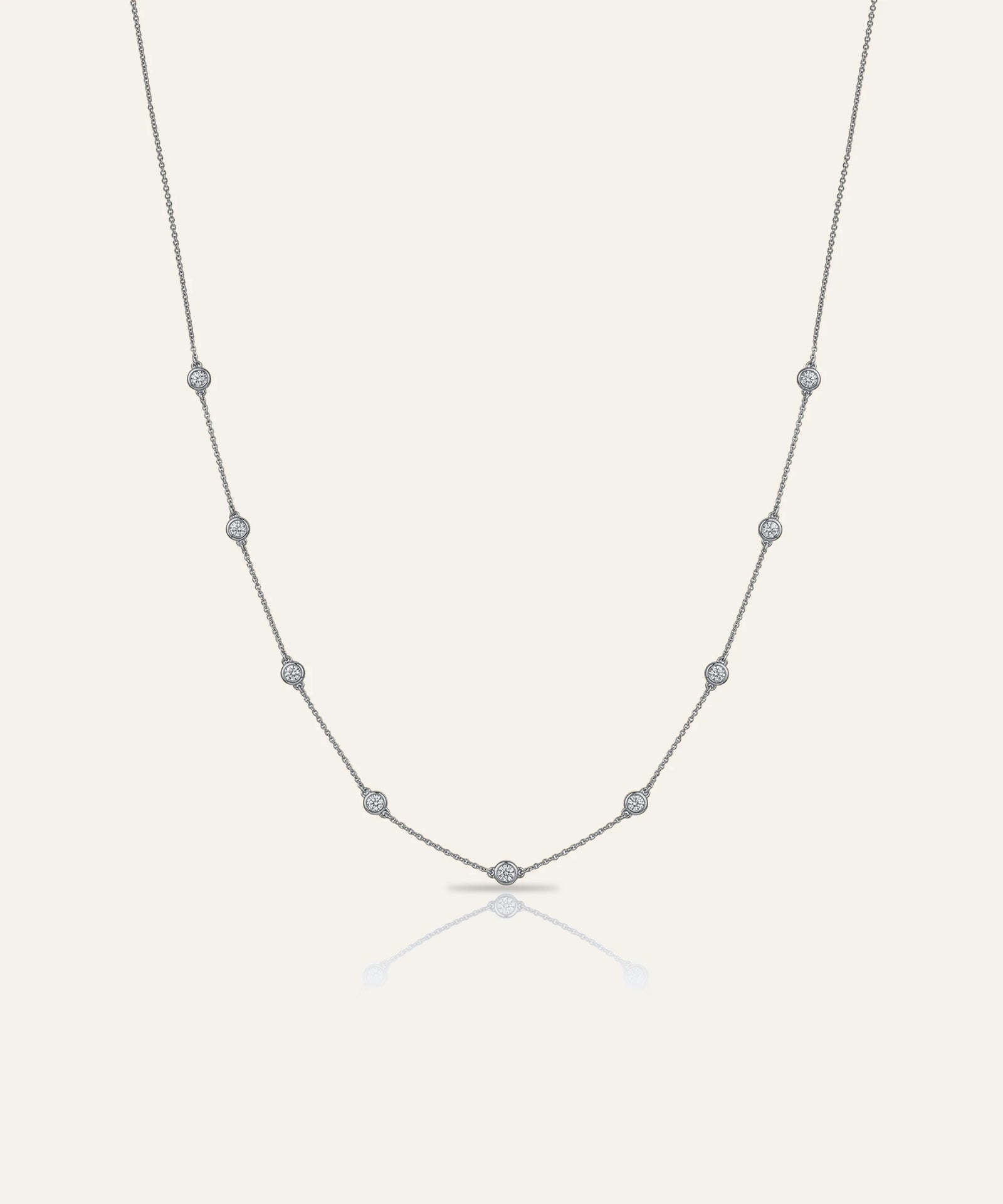 Silver necklace with small beads on a light gray background