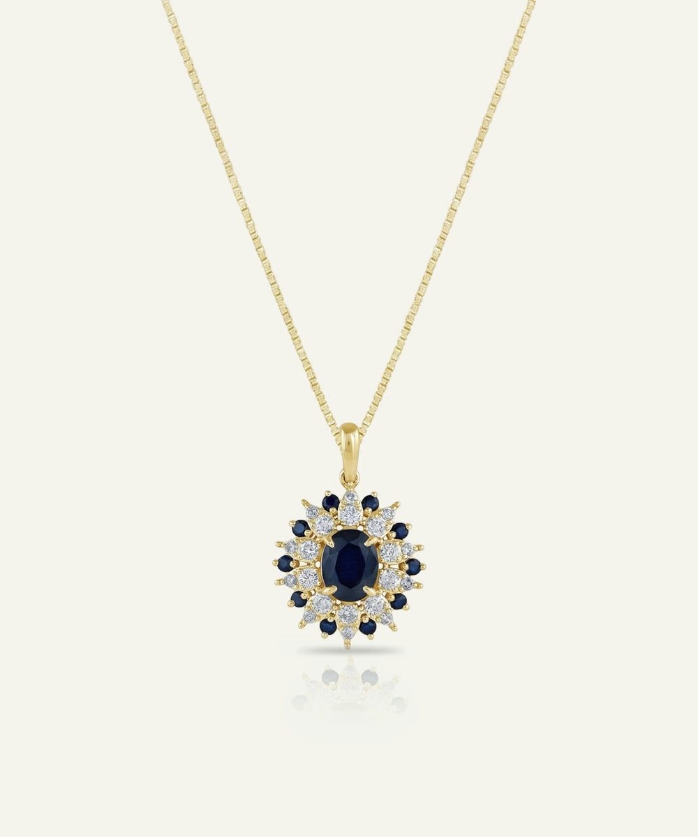 Gold necklace with a pendant featuring a blue gemstone on a white background