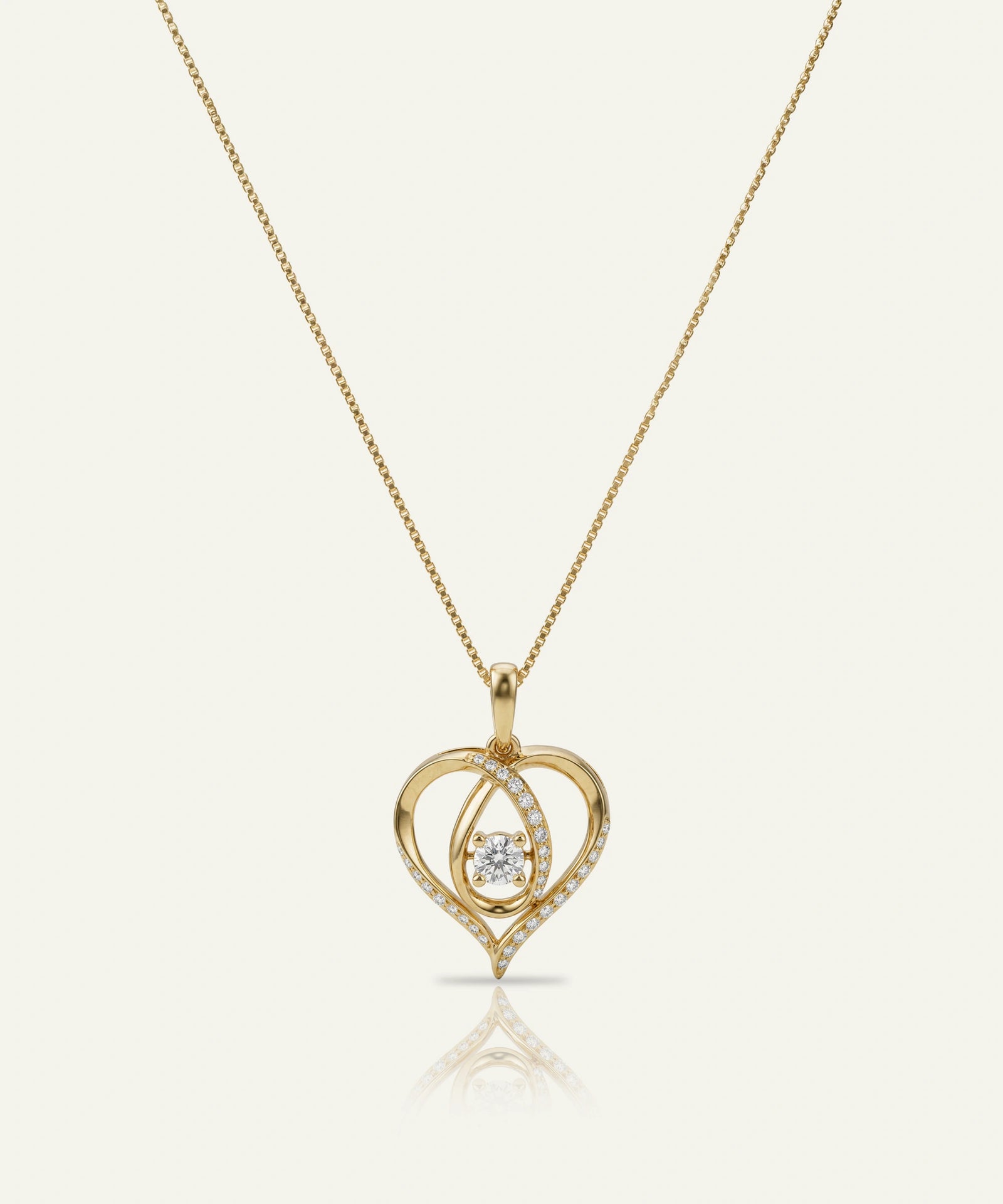Gold heart-shaped pendant necklace with a diamond on a white background