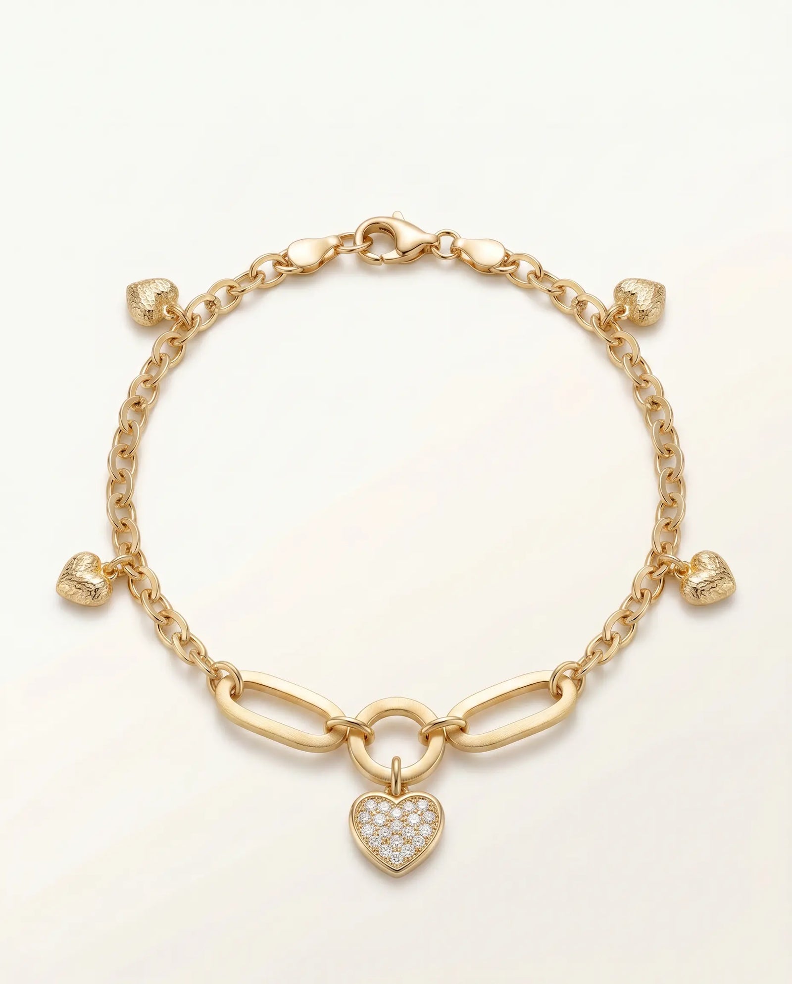 Gold bracelet with a heart-shaped charm on a light beige background