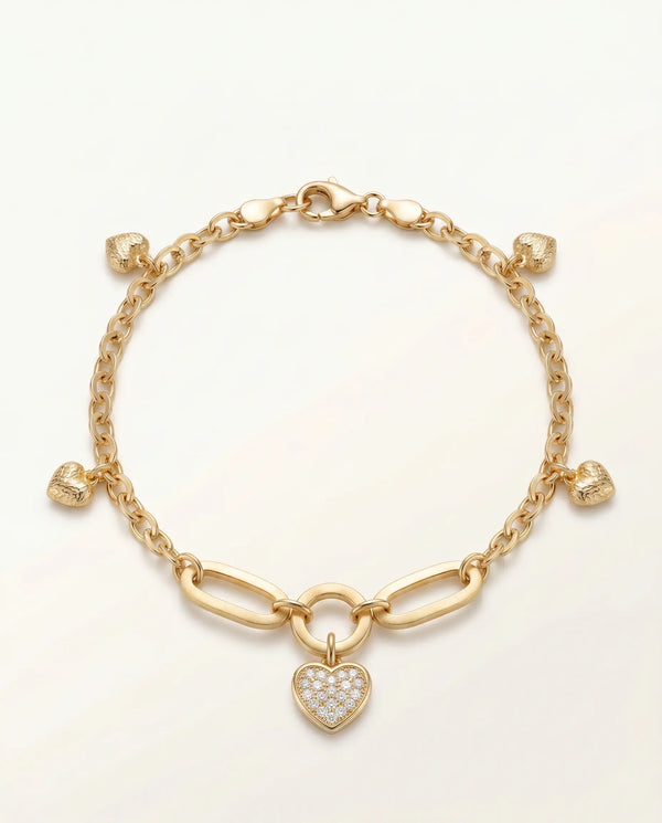 Gold bracelet with a heart-shaped charm on a light beige background