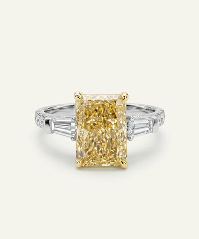 Diamond ring with a yellow diamond center stone on a white background