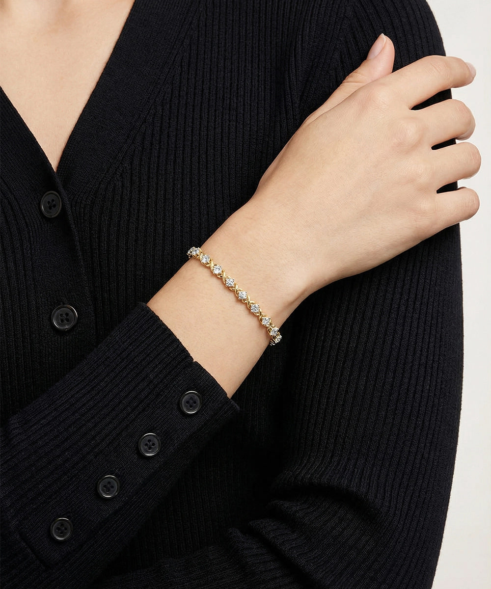 Person wearing a silver bracelet on a plain background