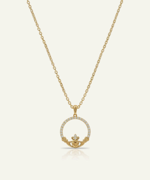 Gold necklace with a claddagh pendant on a white background