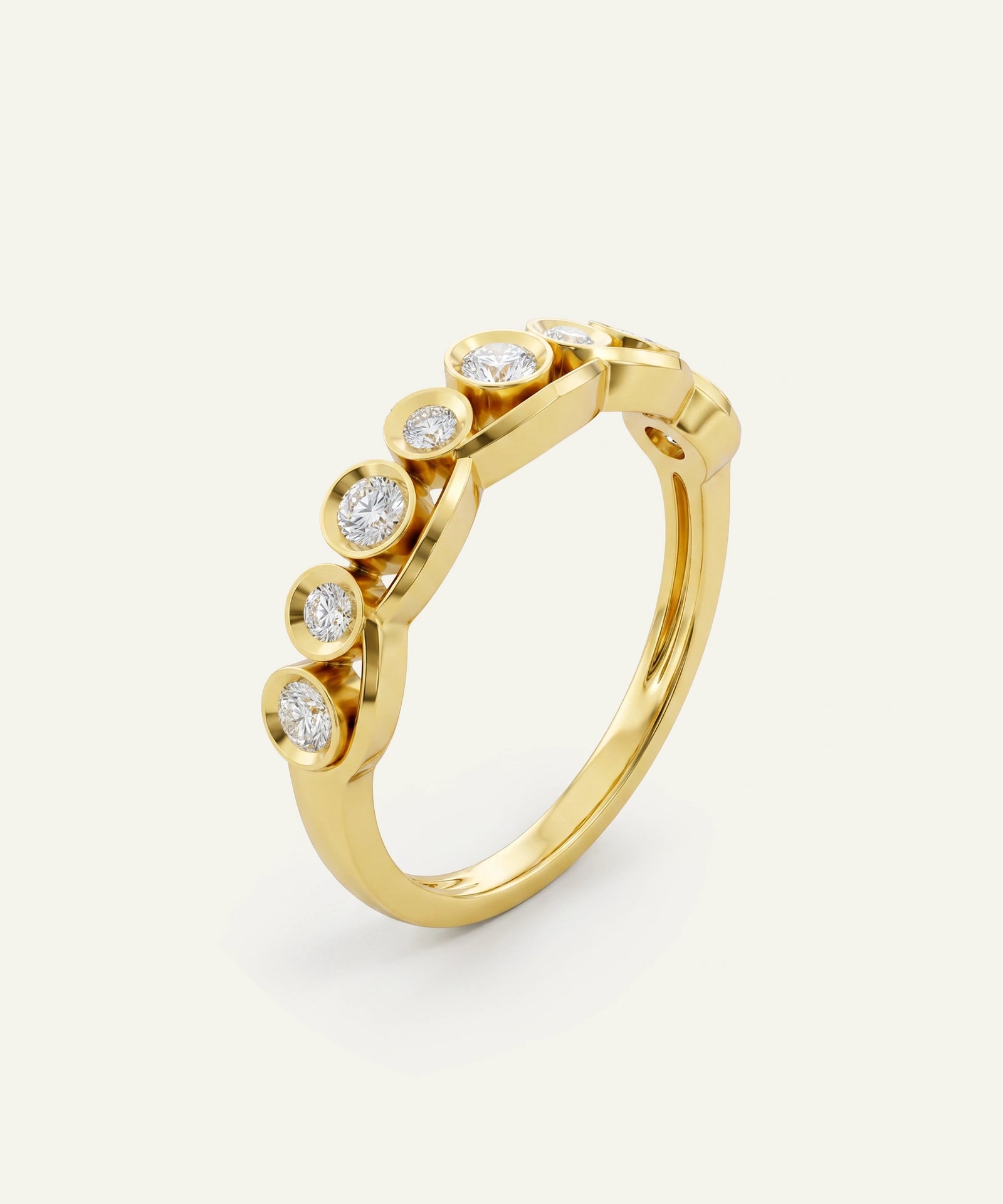 A gold ring featuring a curved top set with five bezel-set round clear gemstones, photographed on a clean off-white background.