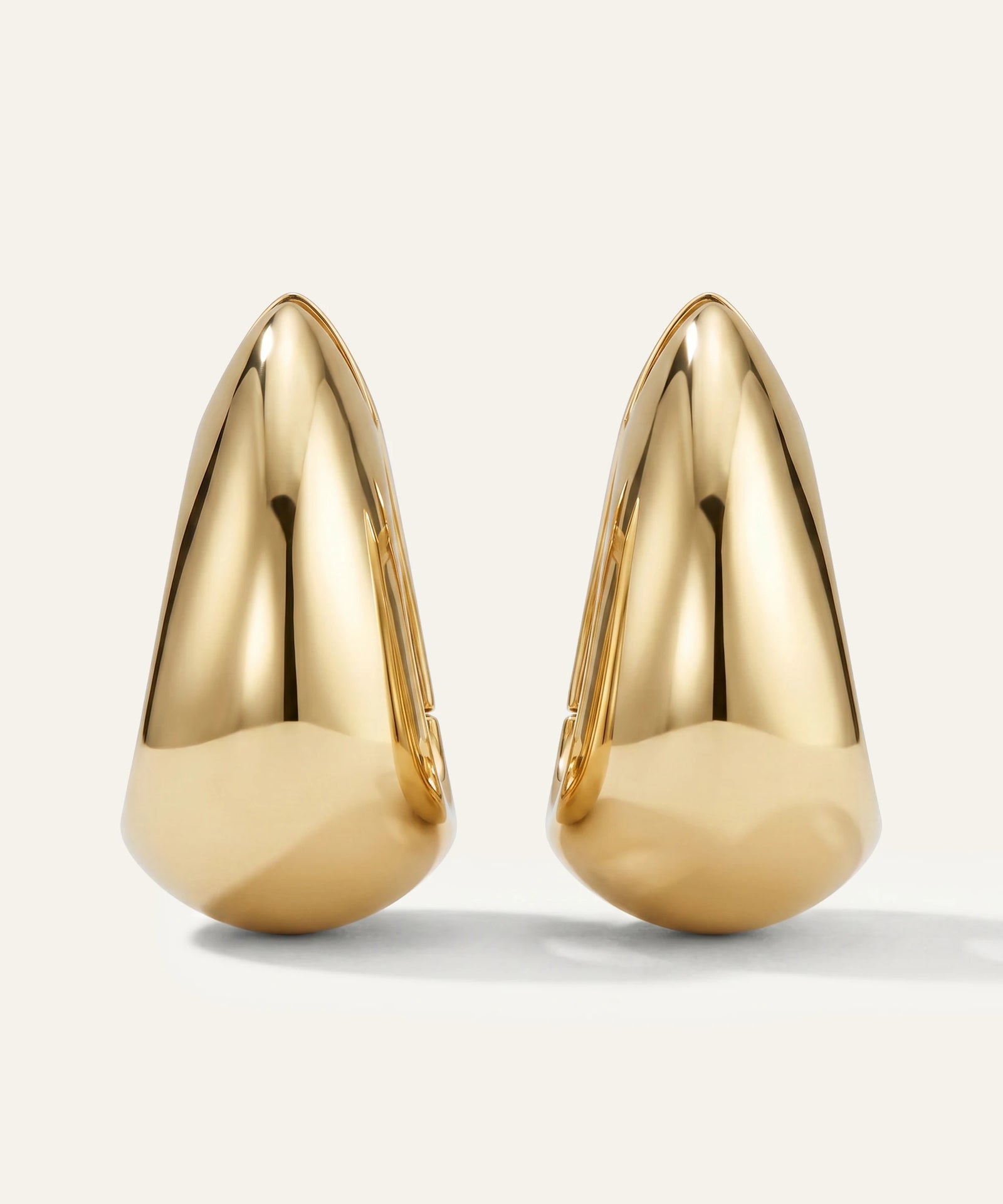 Pair of gold earrings on a light gray background