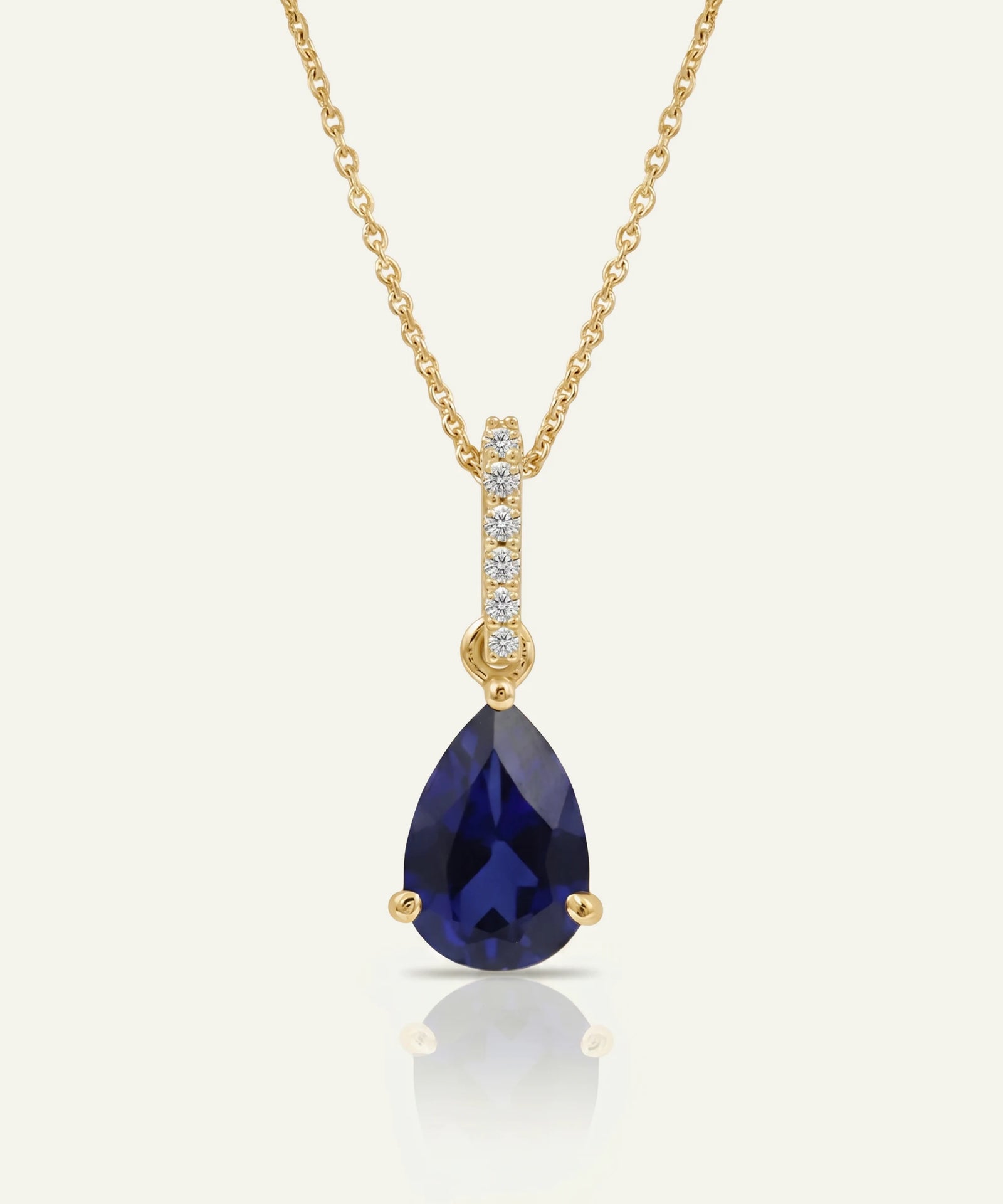 Gold necklace with a hexagonal pendant on a white background