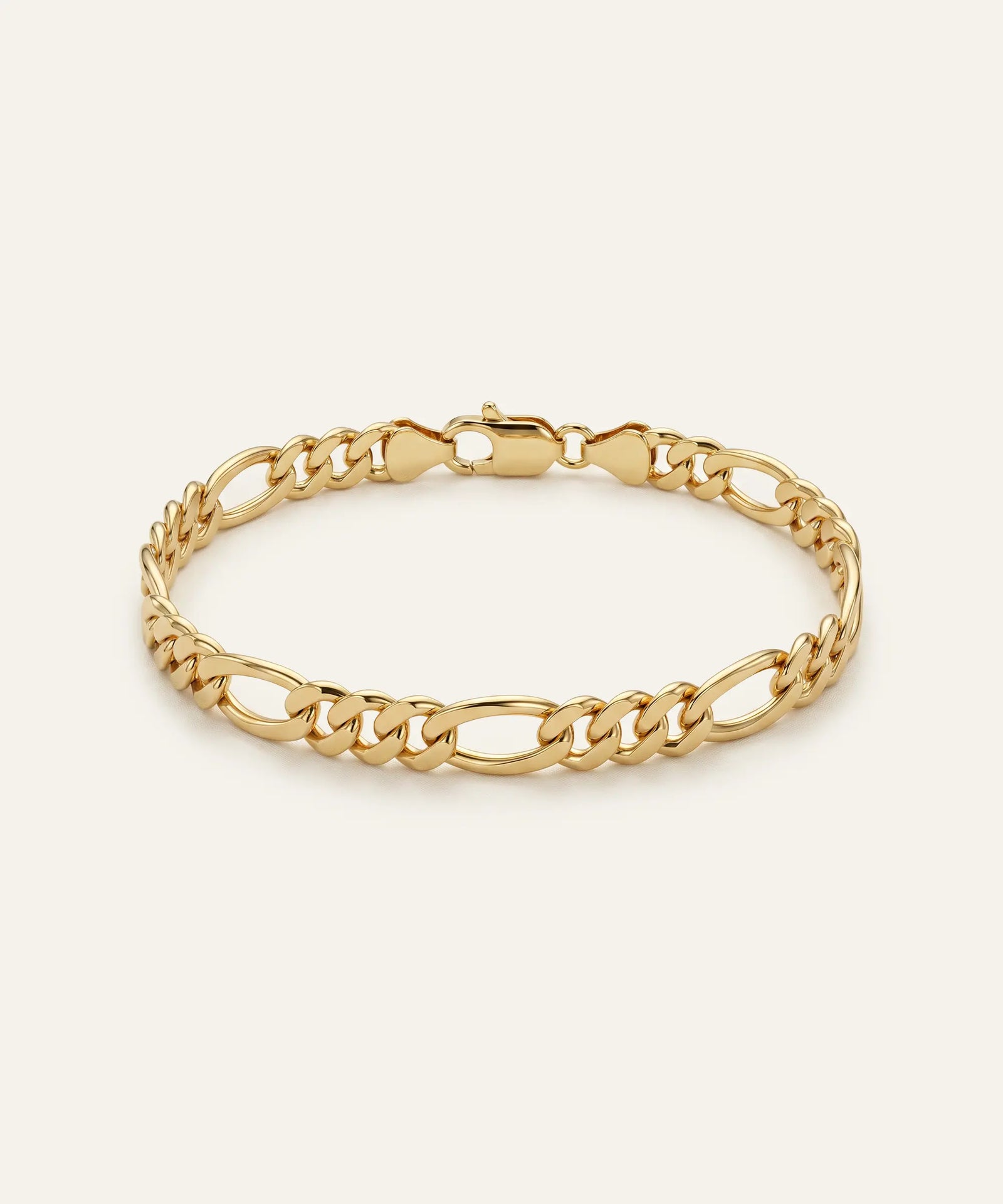 Gold chain bracelet on a light beige background