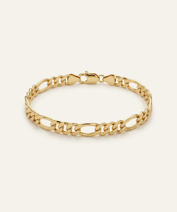 Gold chain bracelet on a light beige background