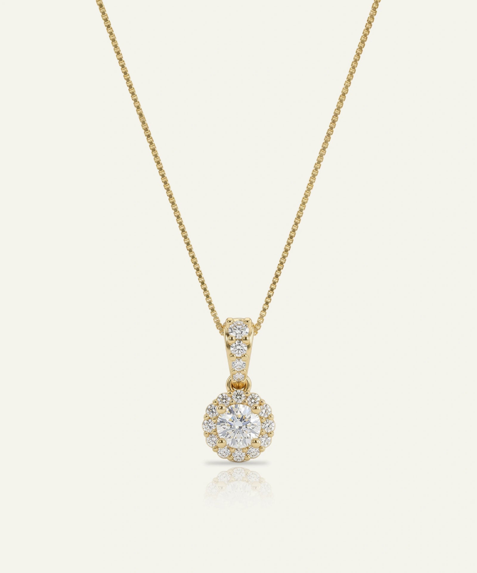 Gold necklace with a diamond pendant on a light beige background