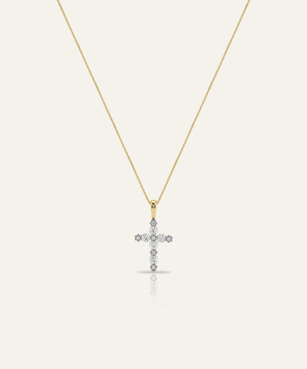 Gold necklace with a diamond cross pendant on a white background