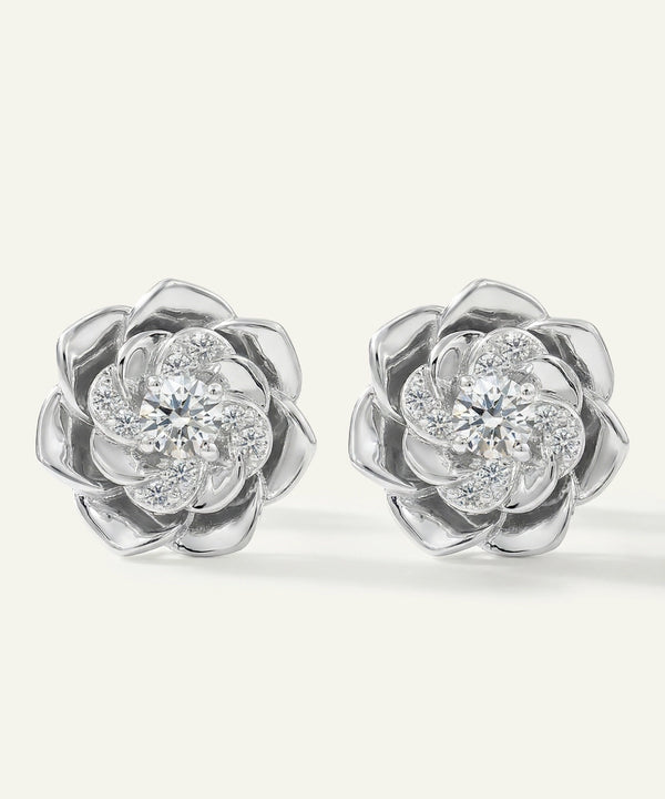 Pair of silver flower-shaped earrings with clear gemstones on a white background