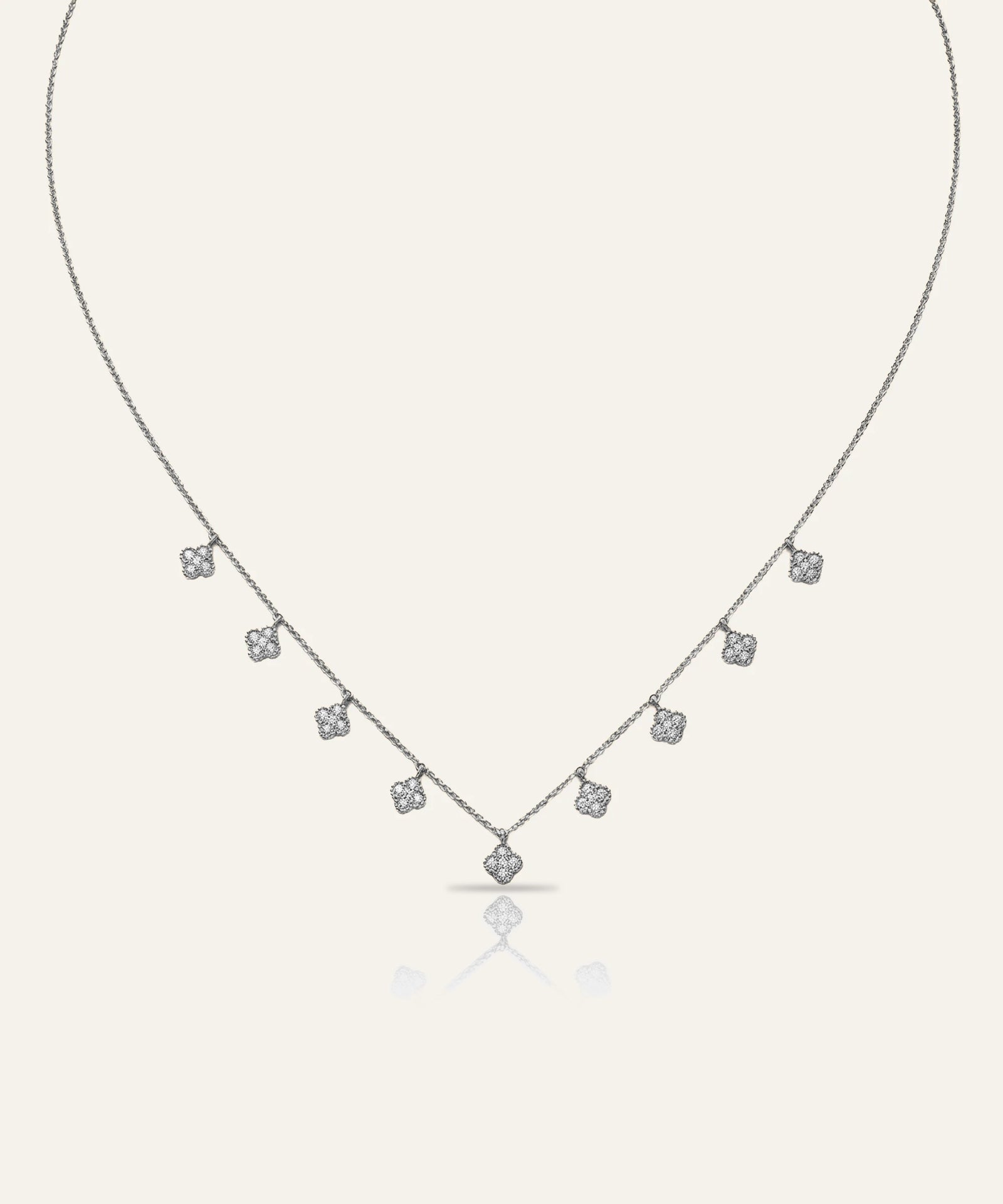 Silver necklace with small diamonds on a light gray background