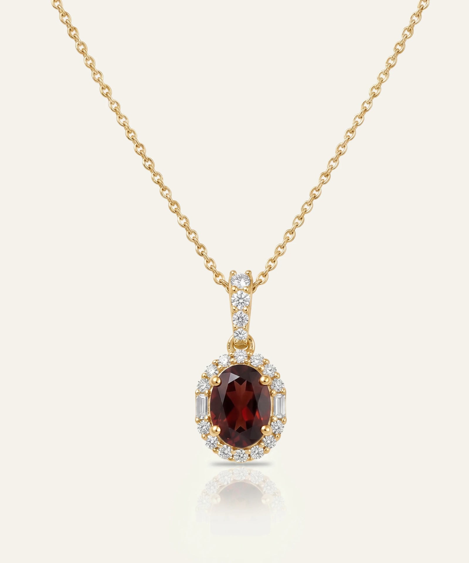 Gold necklace with a garnet pendant on a white background