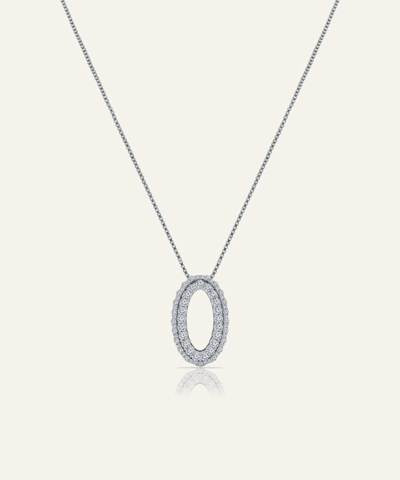 Silver necklace with a round pendant on a light gray background