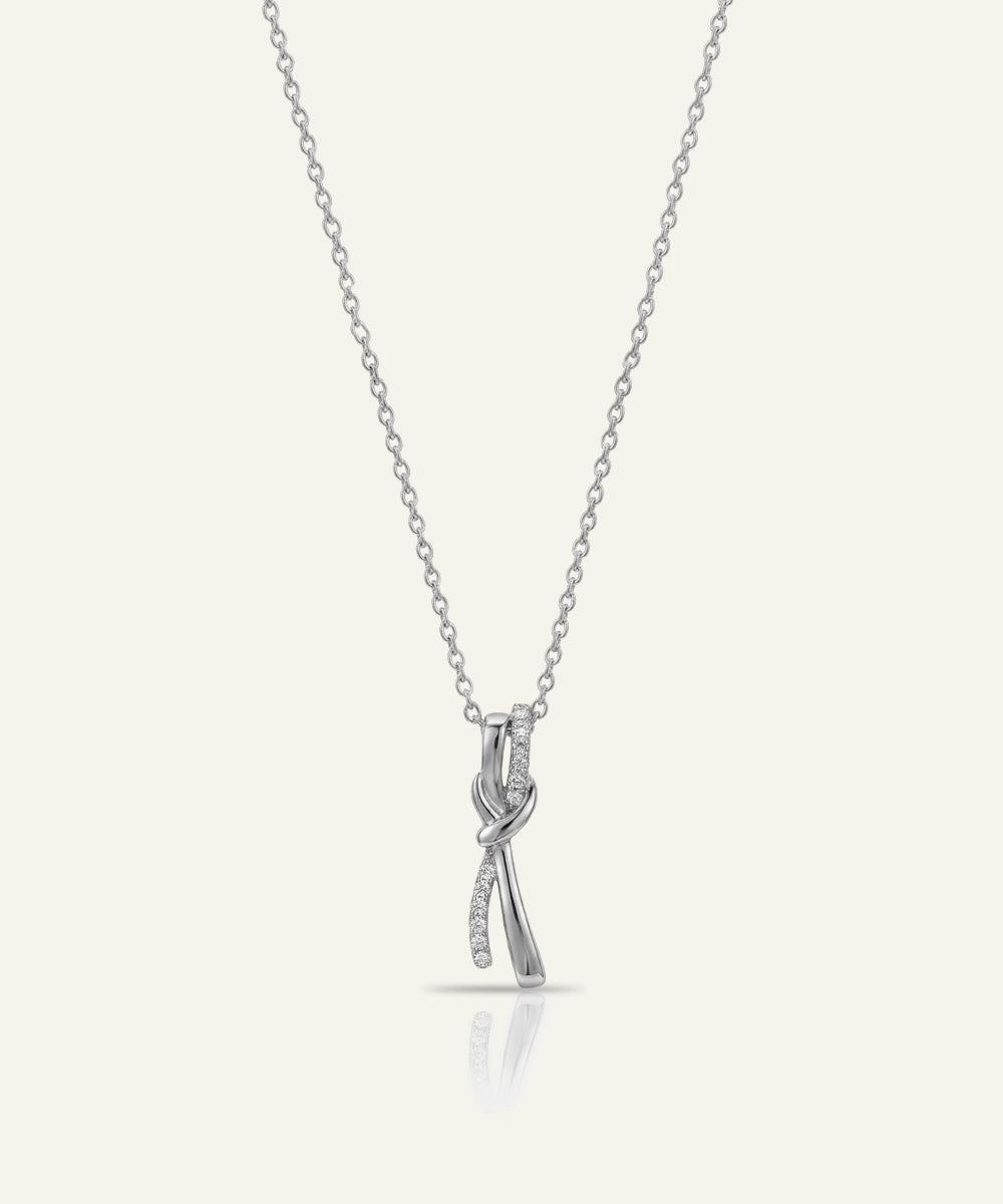 Silver necklace with a bow-shaped pendant on a white background