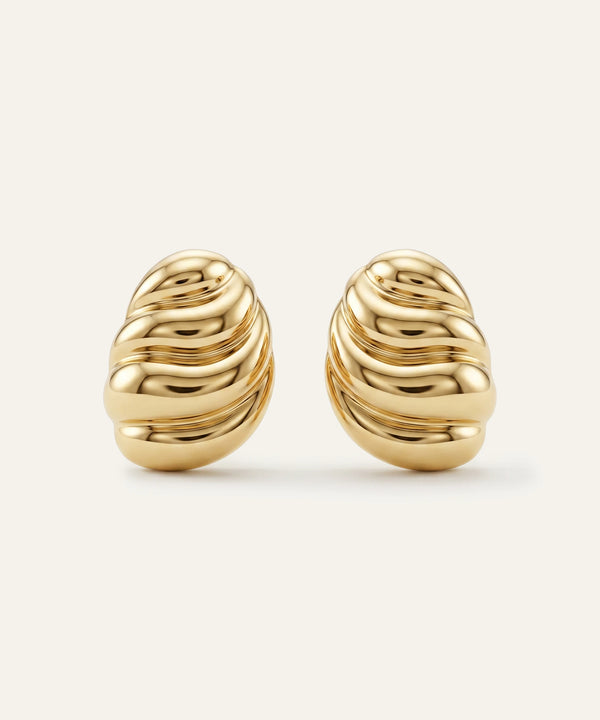 Pair of gold earrings on a light beige background
